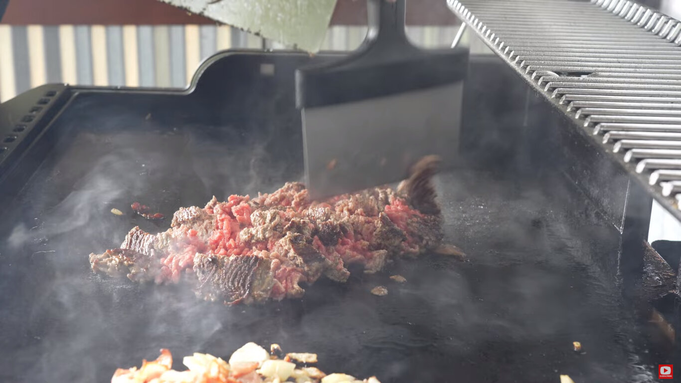Ground beef frying on a griddle